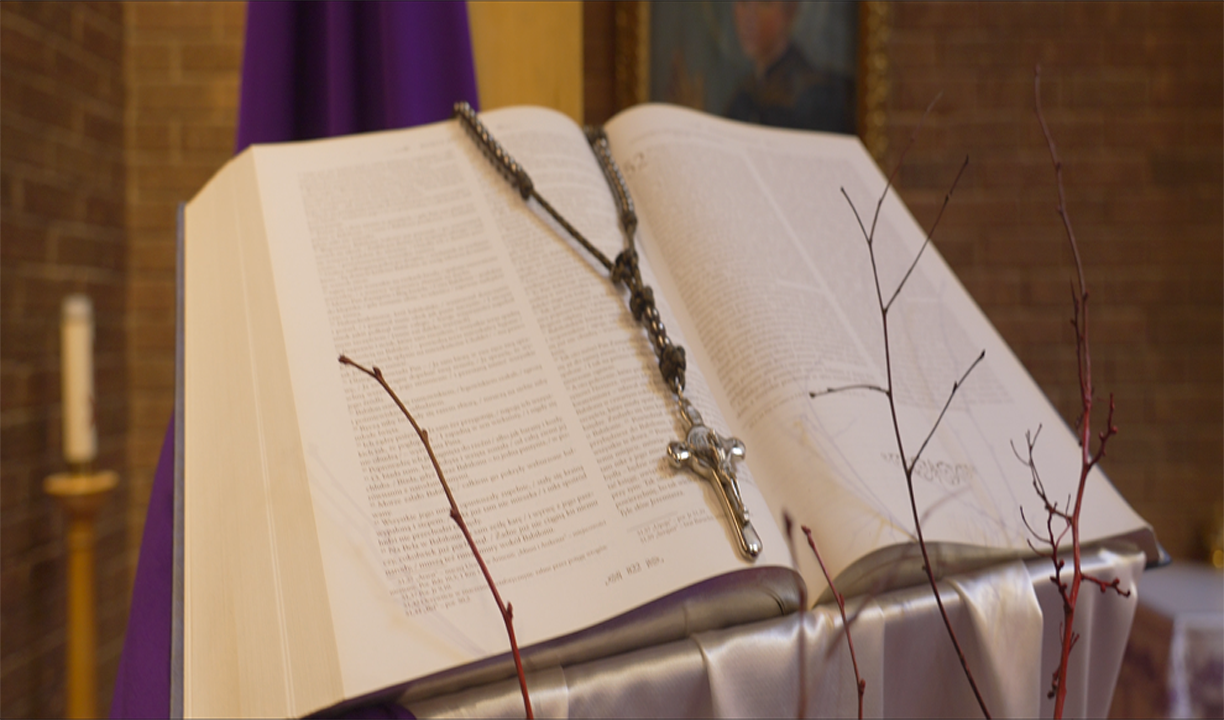 Photo of an open Bible with a Rosary laying on it 